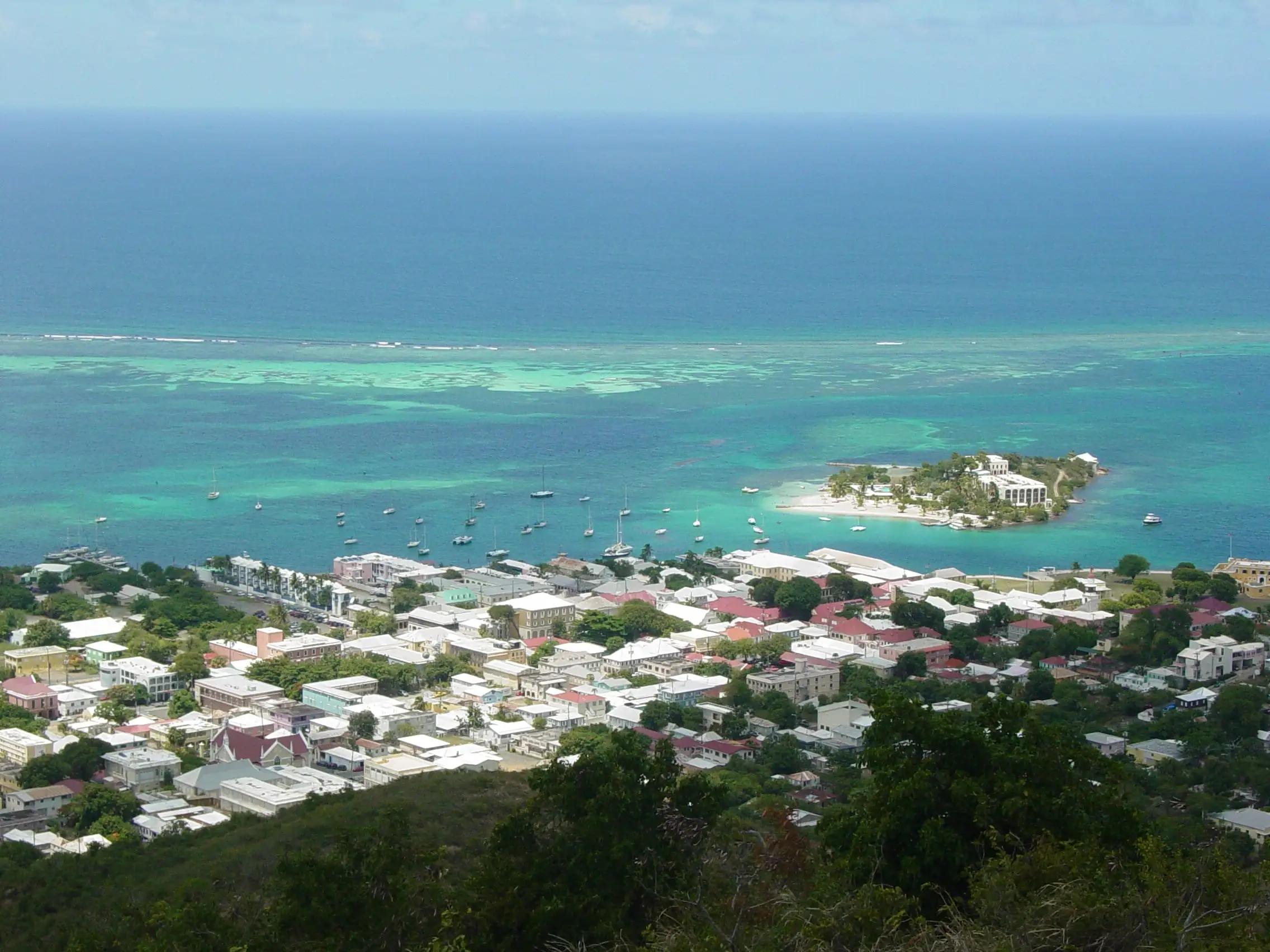 Rooftops of Christiansted and its harbor seen from Recovery Hill, with the reef and open sea beyond