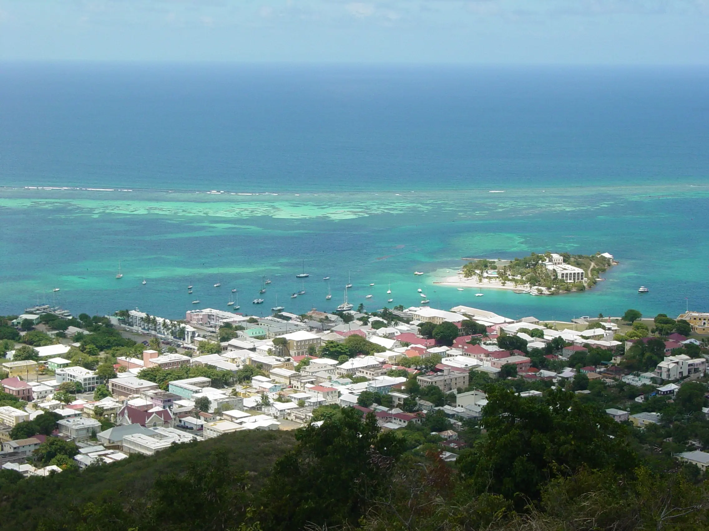Rooftops of Christiansted and its harbor seen from Recovery Hill, with the reef and open sea beyond
