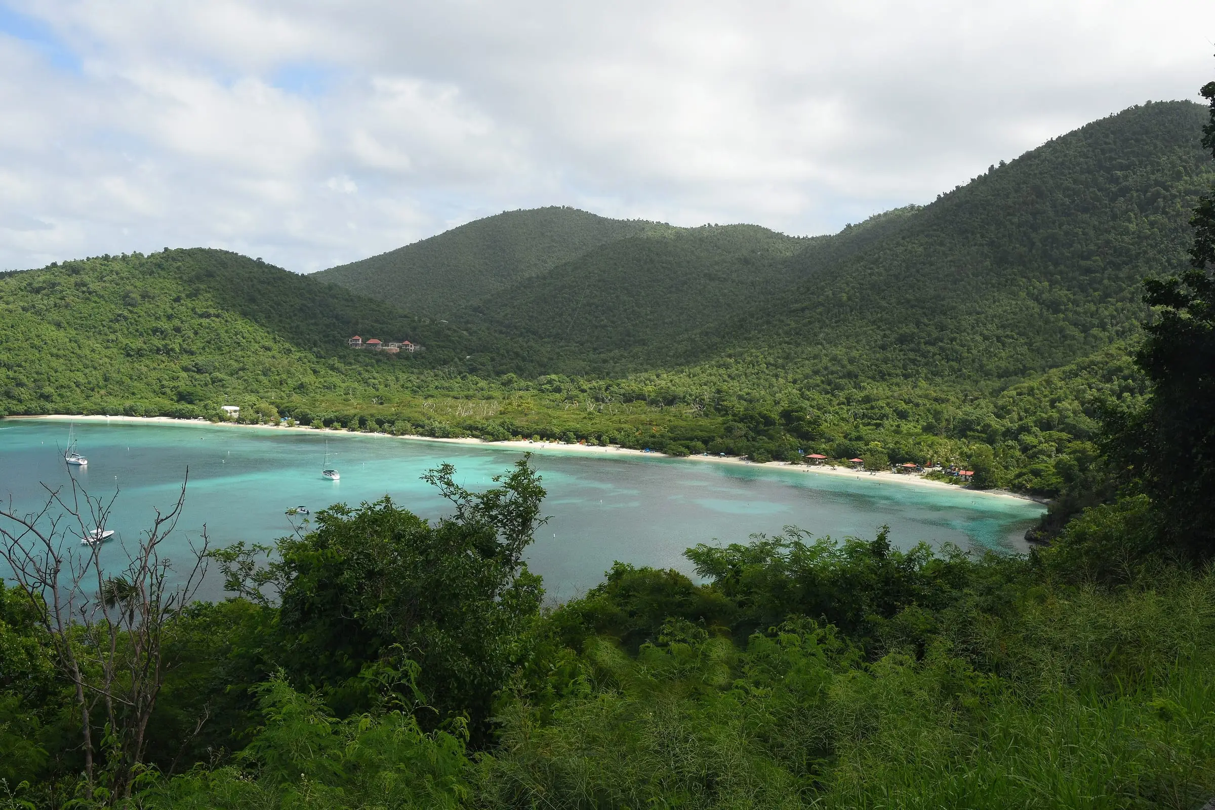 Forested hills rising behind the curving beach at Maho Bay on St. John