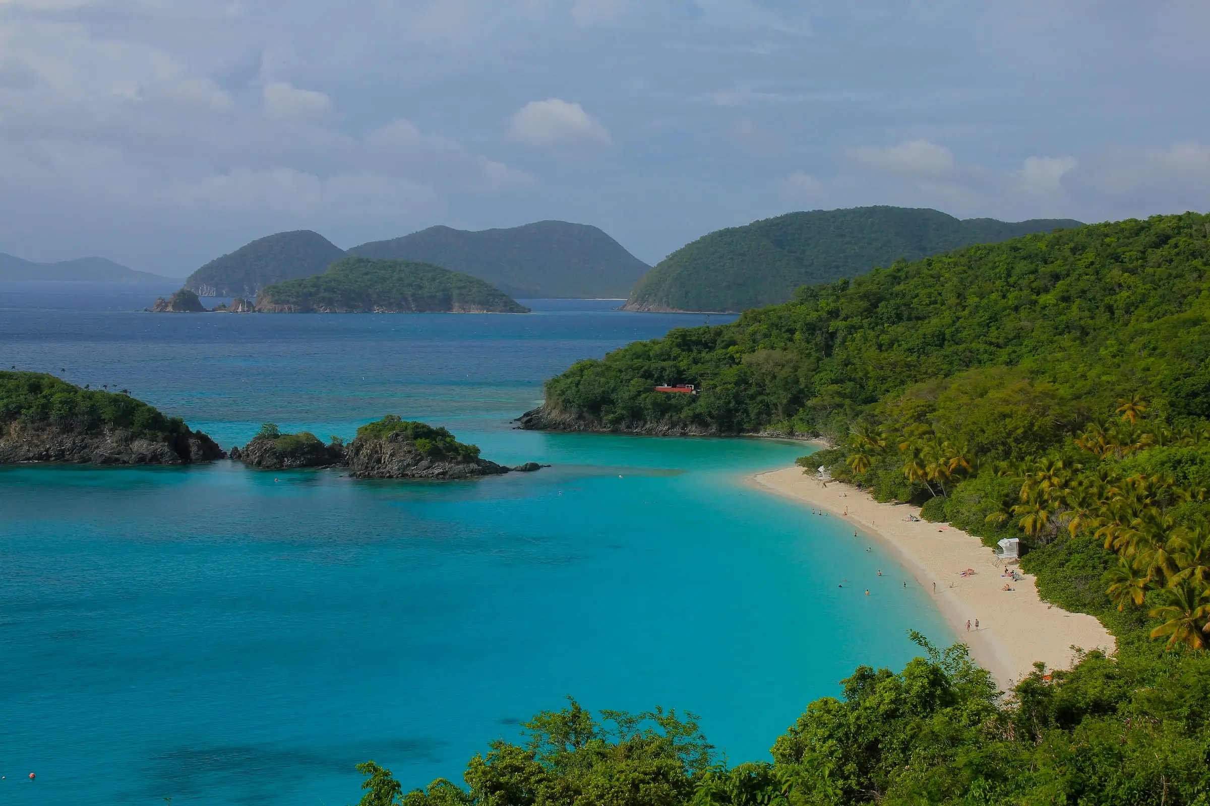 The white beach of Trunk Bay and the small, wooded Trunk Cay seen from the hillside above