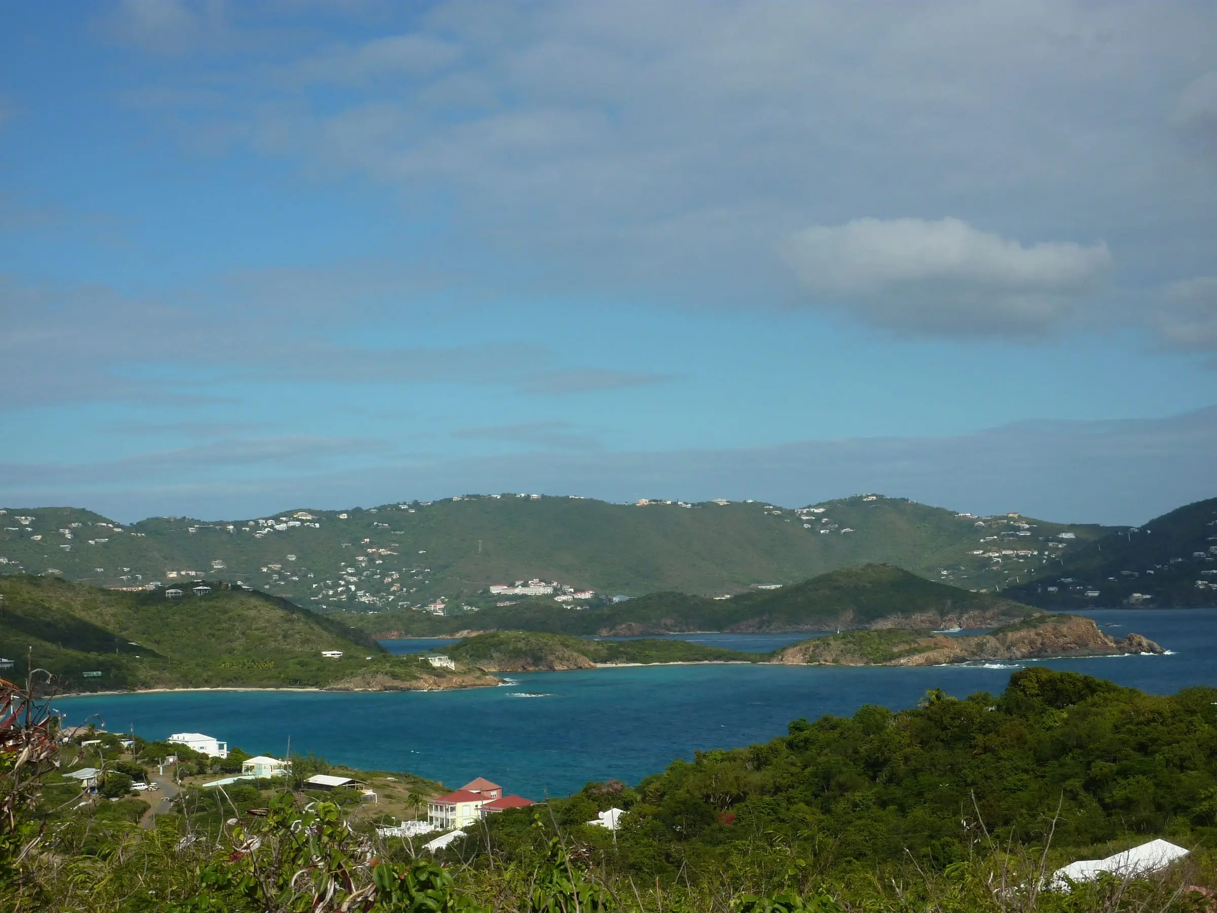Homes on the slopes of Water Island below Fort Segarra, looking north across blue water to the green hills of St. Thomas